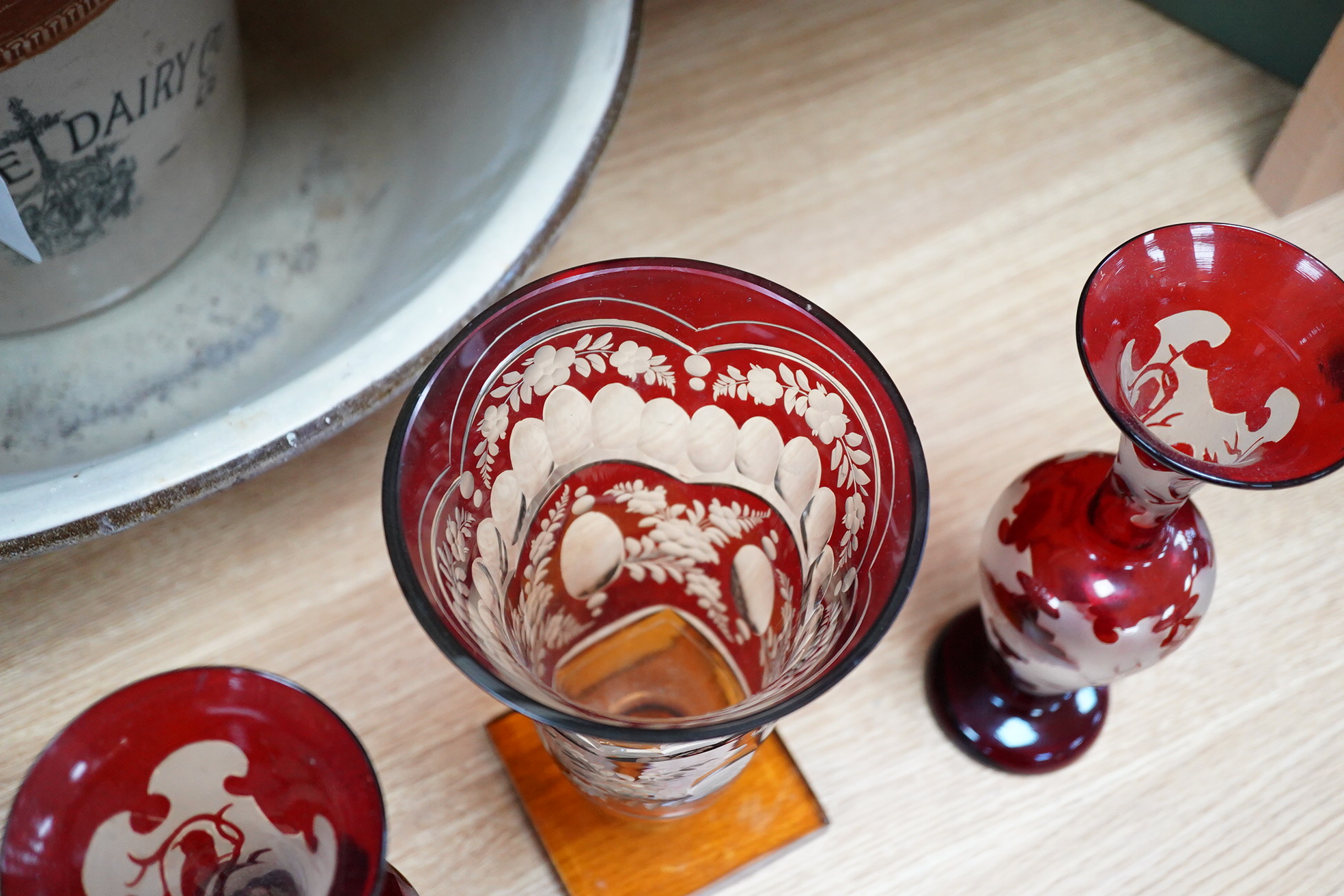 A Czechoslovakian red and amber cut glass square base vase, 21cm high and a pair of similar vases